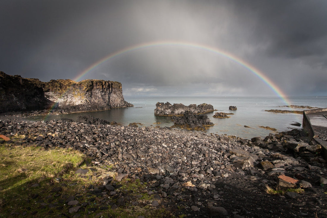 Rainbow over water symbolizing God's everlasting love and promises in Romans 8:31-39